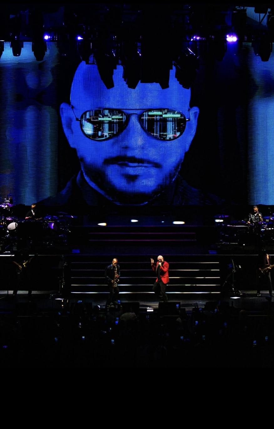Pitbull's face projected on the giant stage screen while Luiso plays below.
