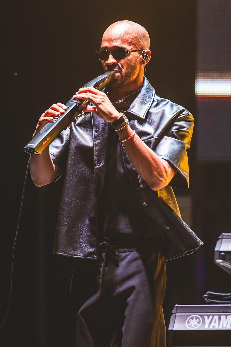 Luiso playing the EWI in a black leather jacket under the stage lights.