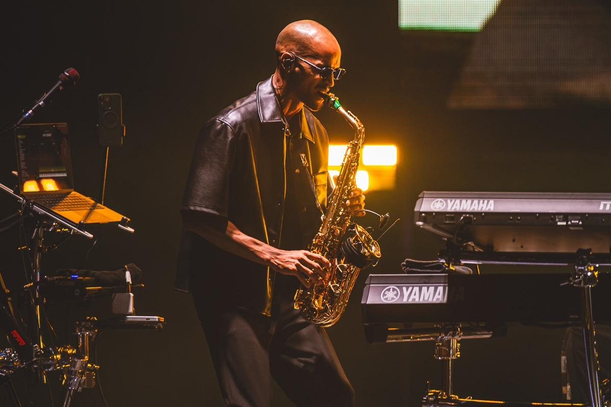 Luiso playing alto saxophone on stage under a warm light.